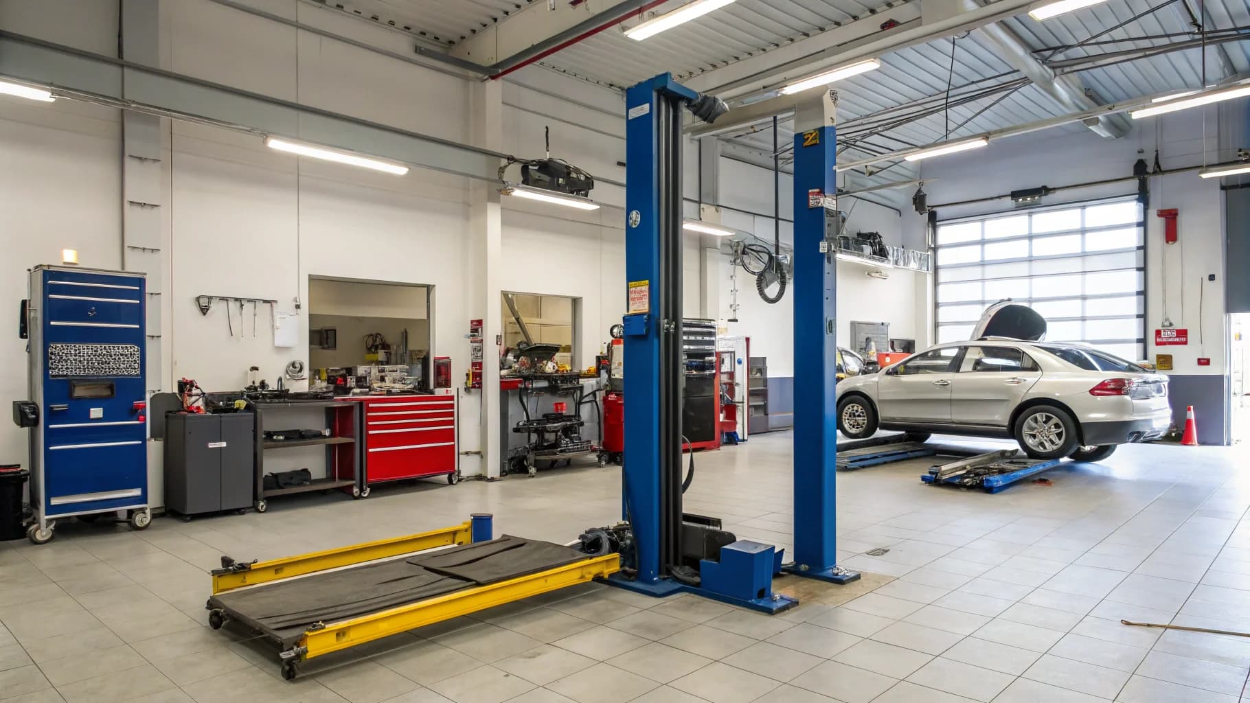 Professional garage workshop with hydraulic lift and diagnostic equipment for major service work, no humans appears in the image